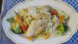 Ein appetitliches Fischgericht mit buntem Gemüse und cremiger Sahnesoße
